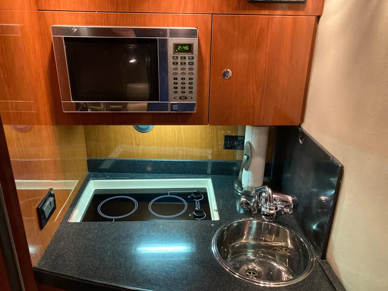 Slide: The Image of Compact kitchen in 2007 Regal 3760 Commodore yacht with microwave, stove, and sink. - 41