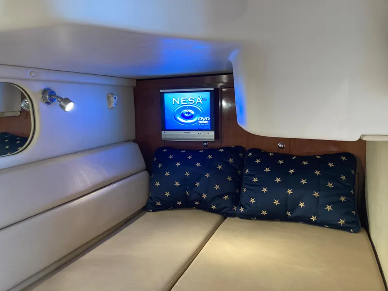 Slide: The Image of 2007 Regal 3760 Commodore cabin with TV, star-patterned pillows, and cozy seating. - 47