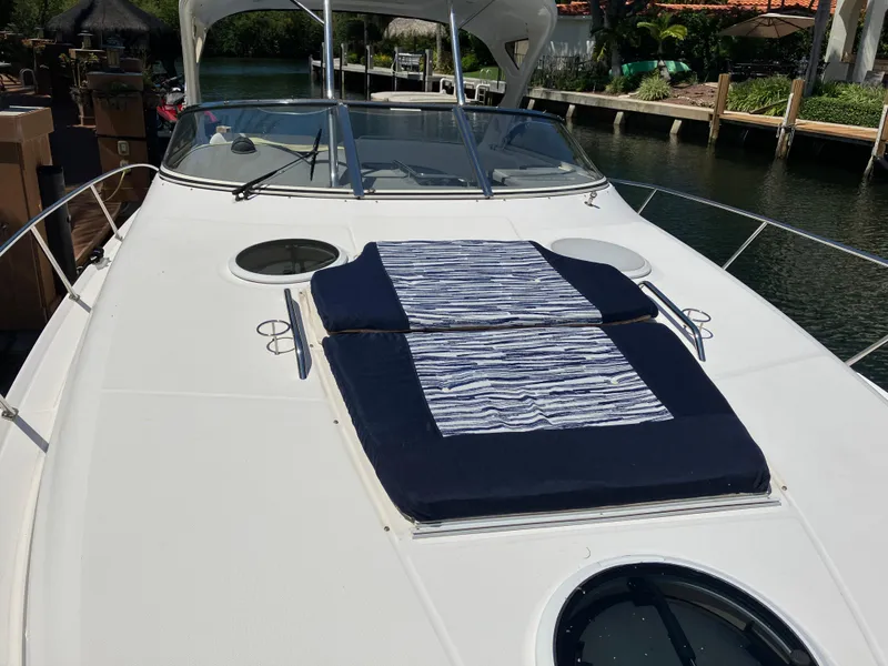 Slide: The Image of 2007 Regal 3760 Commodore yacht with sunbathing cushions on deck, docked by a canal. - 7