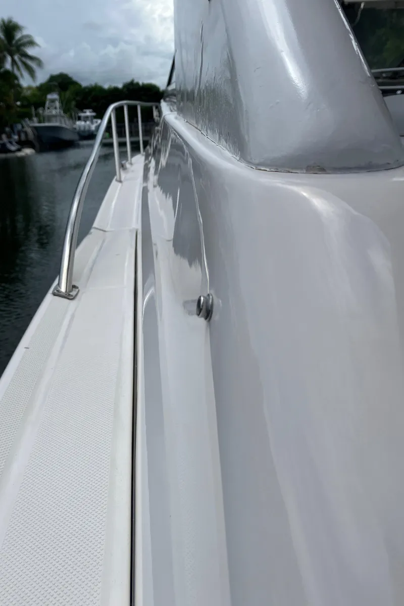 Slide: The Image of 2007 Regal 3760 Commodore yacht, side view with railing, docked near palm trees. - 9
