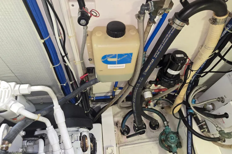 Slide: The Image of Engine room of 2012 American Tug 365 Flybridge with hoses and coolant tank. - 105