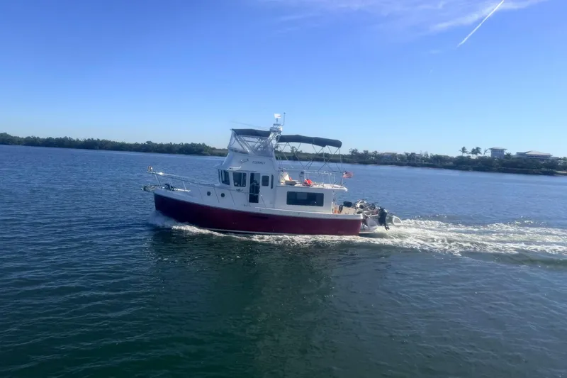 Slide: The Image of American Tug 365 Flybridge 2012 cruising on a sunny day in calm waters. - 111