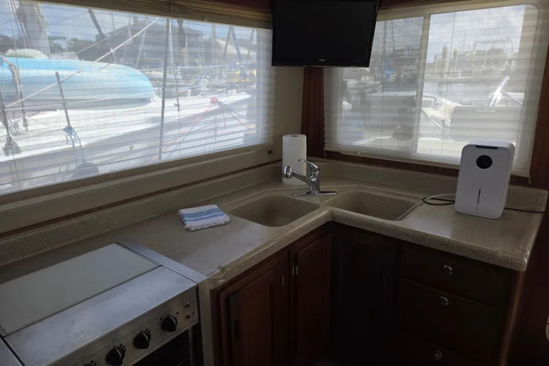 Slide: The Image of Interior view of 2012 American Tug 365 Flybridge kitchen with sink, stove, and windows. - 19