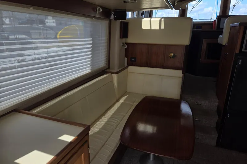 Slide: The Image of Interior of 2012 American Tug 365 Flybridge with beige seating and wooden table. - 27