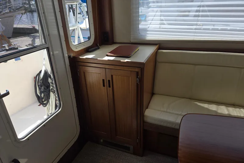 Slide: The Image of Interior of 2012 American Tug 365 Flybridge with wooden cabinetry and cream seating. - 29