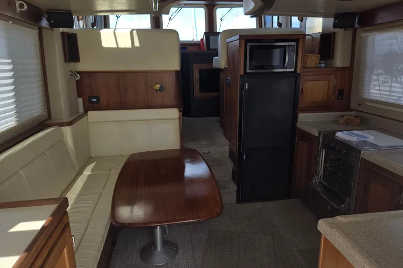 Slide: The Image of Interior of 2012 American Tug 365 Flybridge with dining area and kitchen amenities. - 3