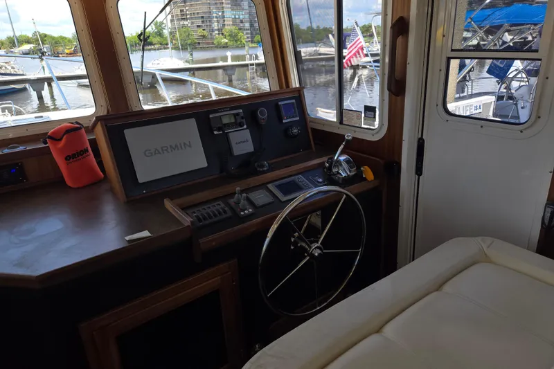 Slide: The Image of American Tug 365 Flybridge 2012 helm with Garmin navigation, dock view, and control panel. - 31