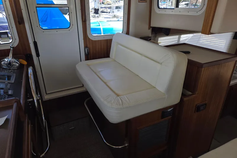 Slide: The Image of Interior of 2012 American Tug 365 Flybridge with white seating and control panel. - 34