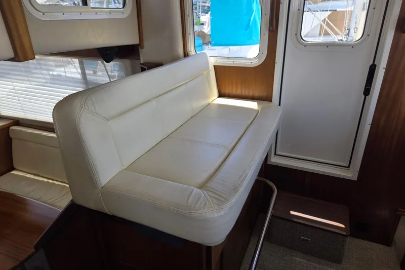 Slide: The Image of Interior of 2012 American Tug 365 Flybridge with white seating and window view. - 35
