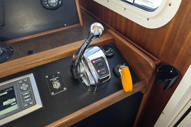Slide: The Image of Control panel of a 2012 American Tug 365 Flybridge with throttle and navigation controls. - 42