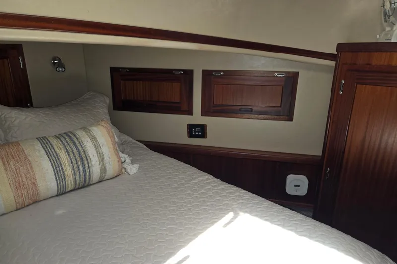 Slide: The Image of Cozy cabin interior of 2012 American Tug 365 Flybridge with wood accents and bedding. - 45