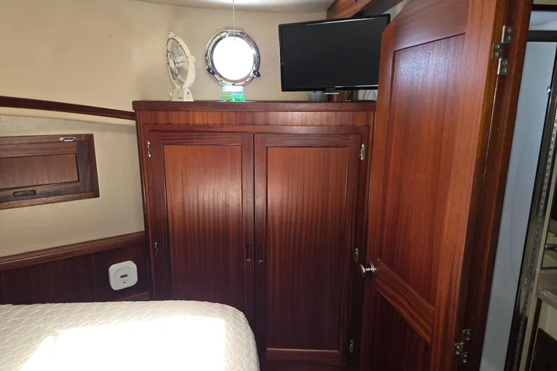 Slide: The Image of Interior of 2012 American Tug 365 Flybridge with wooden cabinetry and porthole window. - 47