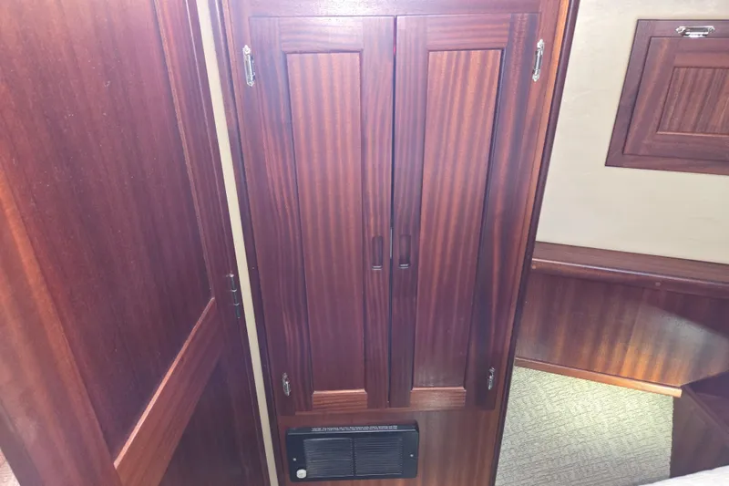 Slide: The Image of Wooden interior of 2012 American Tug 365 Flybridge, featuring a cabinet and heater vent. - 51