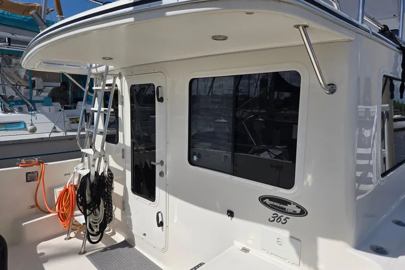 Slide: The Image of American Tug 365 Flybridge 2012, featuring a sleek exterior with ladder and mooring ropes. - 59