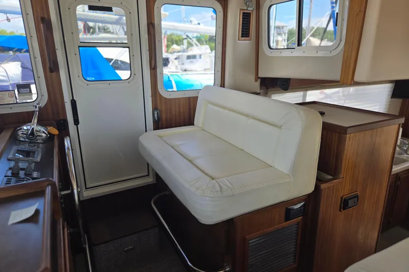 Slide: The Image of Interior of 2012 American Tug 365 Flybridge with white seating and wooden accents. - 6