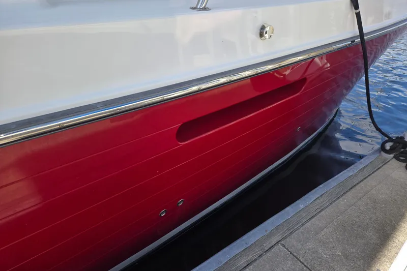 Slide: The Image of Red hull of a 2012 American Tug 365 Flybridge docked by the water. - 69