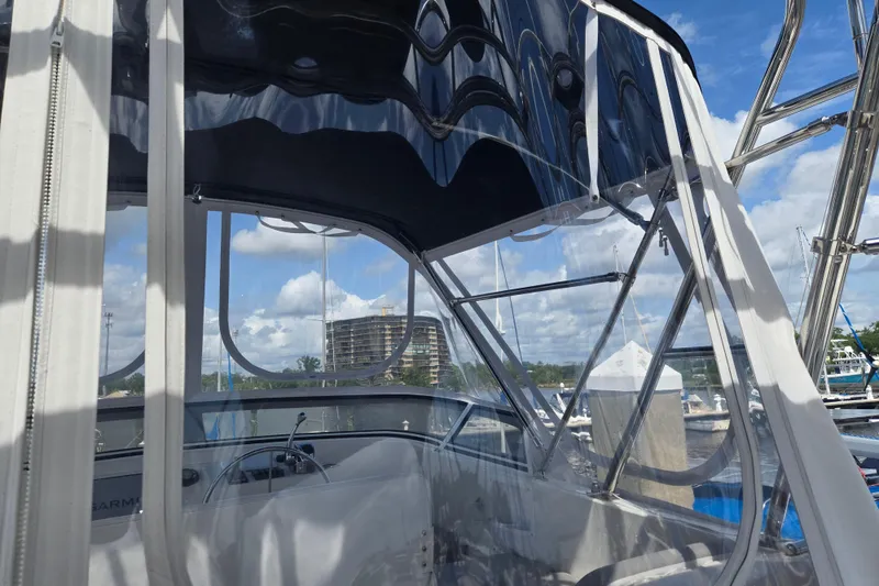Slide: The Image of Flybridge view of 2012 American Tug 365, showcasing helm and marina backdrop. - 71