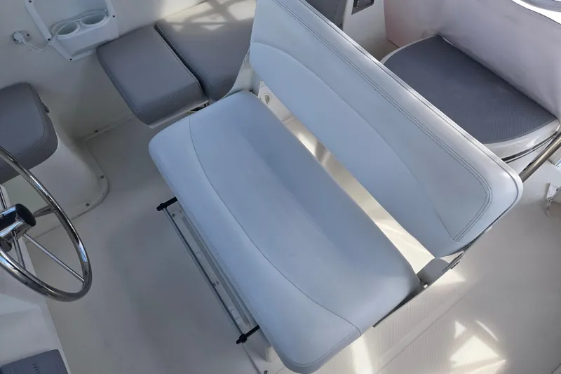 Slide: The Image of Captain's seat on 2012 American Tug 365 Flybridge, featuring white upholstery and steering wheel. - 73