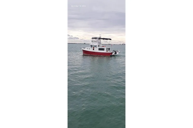 Slide: The Image of American Tug 365 Flybridge 2012 on calm waters under cloudy sky. - 83
