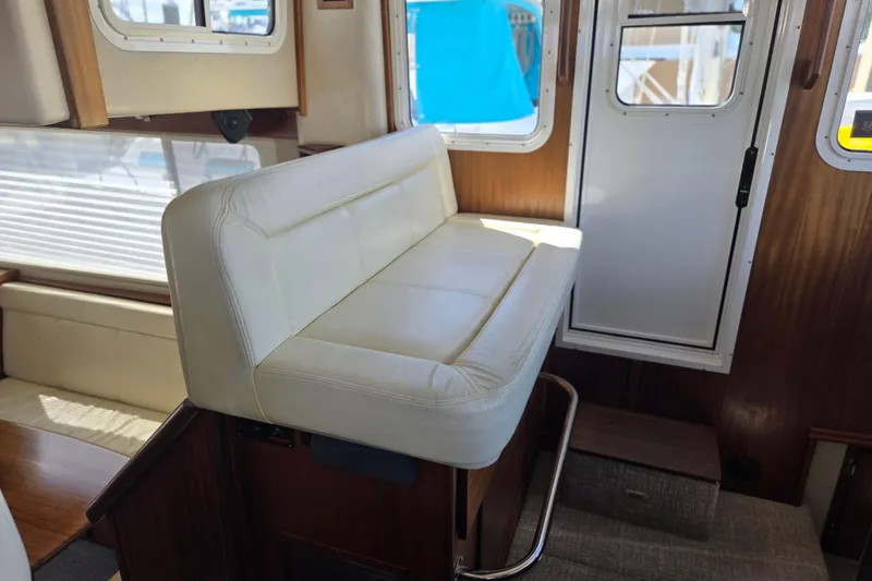 Slide: The Image of Interior of 2012 American Tug 365 Flybridge with white seating and wooden accents. - 9