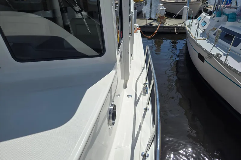 Slide: The Image of American Tug 365 Flybridge 2012 docked, showcasing sleek design and sturdy railings. - 94