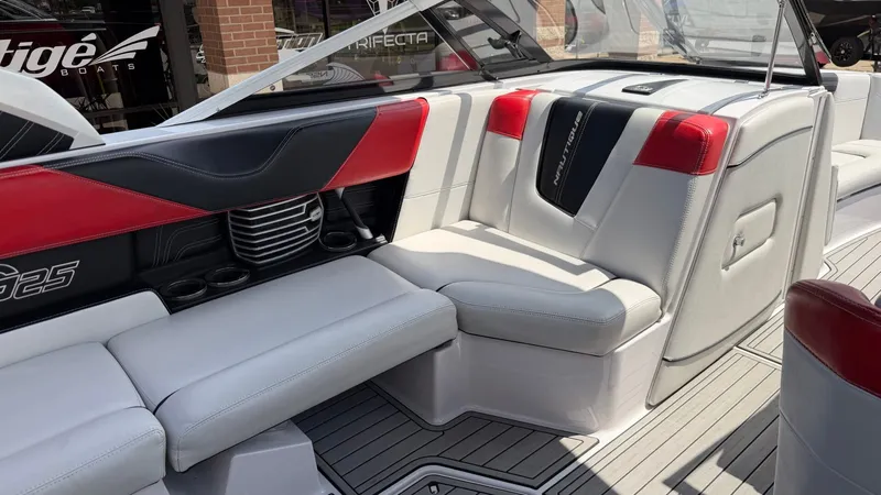 Slide: The Image of Interior of a 2014 Nautique G25 boat with red and gray seating. - 12