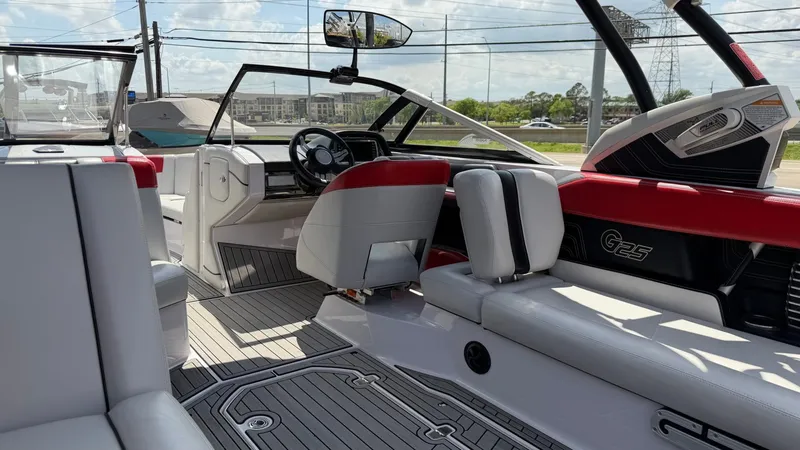 Slide: The Image of Interior of a 2014 Nautique G25 boat with red and white seating. - 13