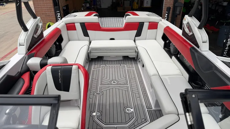 Slide: The Image of Interior of a 2014 Nautique G25 boat with red and white seating. - 15