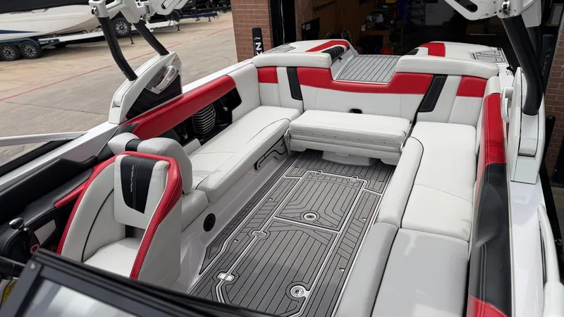 Slide: The Image of Interior of a 2014 Nautique G25 boat with red and white seating. - 16