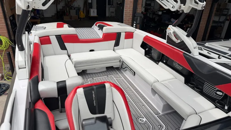 Slide: The Image of Interior of a 2014 Nautique G25 boat with red and white seating. - 17