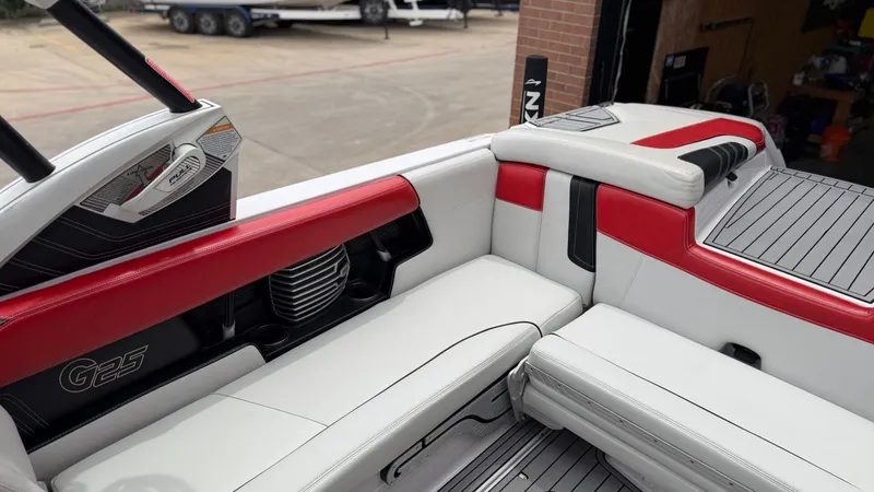 Slide: The Image of Interior of a 2014 Nautique G25 boat with red and white seating. - 18