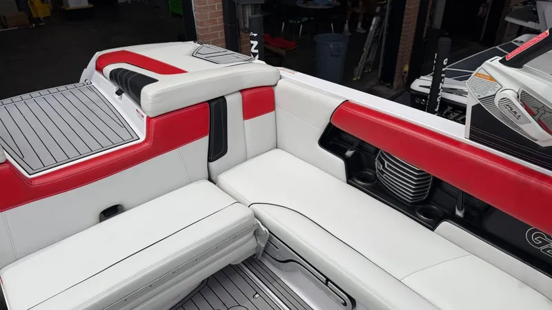 Slide: The Image of Interior of a 2014 Nautique G25 boat with red and white seating. - 19