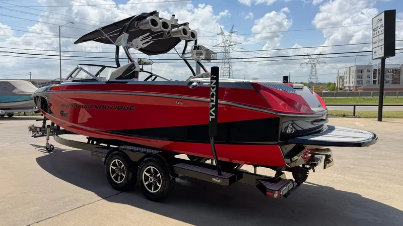 Slide: The Image of Red 2014 Nautique G25 boat on trailer outdoors. - 6