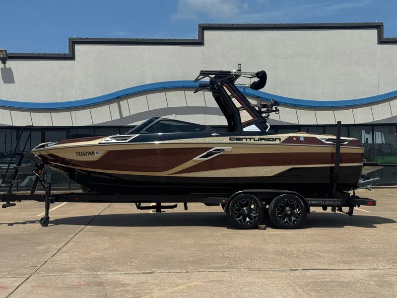 The Image of 2023 Centurion Ri230 boat on trailer in front of building. - 1