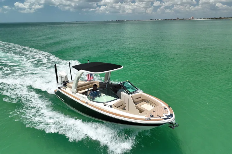 Slide: The Image of 2023 Chris-Craft Launch 25 GT cruising on turquoise waters under a partly cloudy sky. - 11