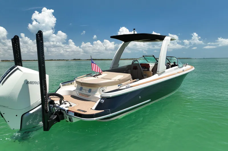 Slide: The Image of 2023 Chris-Craft Launch 25 GT boat on turquoise water under a clear sky. - 14