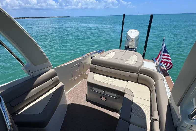 Slide: The Image of 2023 Chris-Craft Launch 25 GT boat interior with seating, American flag, and ocean view. - 18