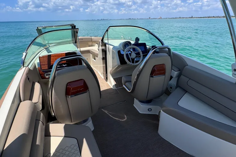 Slide: The Image of 2023 Chris-Craft Launch 25 GT interior with luxurious seating and steering, overlooking the ocean. - 26