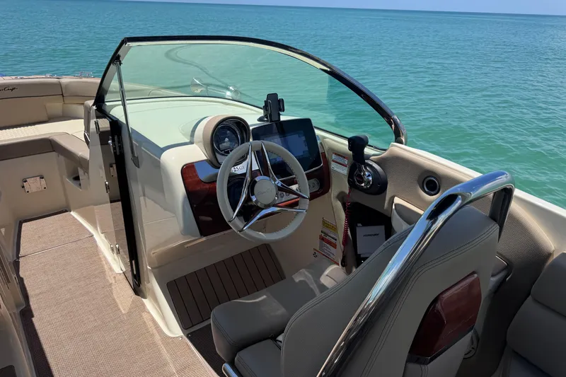 Slide: The Image of 2023 Chris-Craft Launch 25 GT boat interior with steering wheel and dashboard, overlooking the ocean. - 27