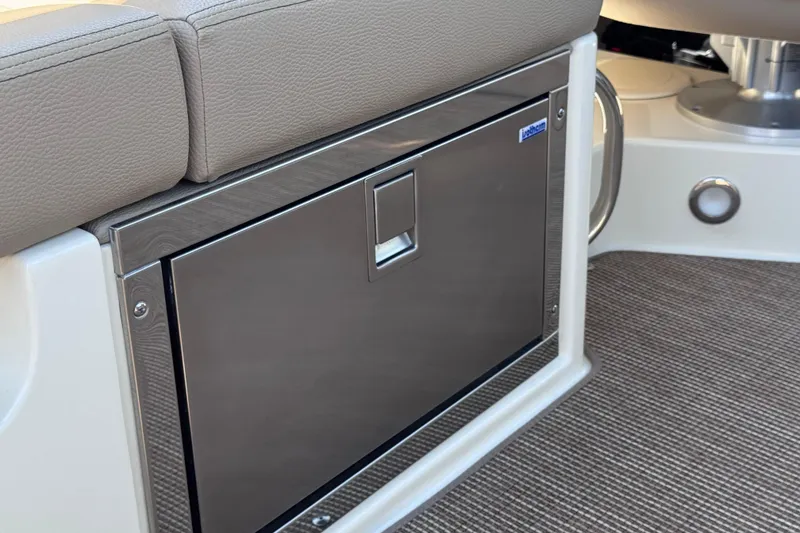 Slide: The Image of 2023 Chris-Craft Launch 25 GT interior with stainless steel storage compartment and beige seating. - 30