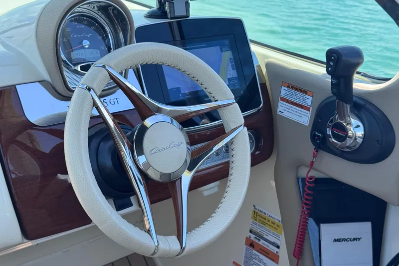Slide: The Image of 2023 Chris-Craft Launch 25 GT dashboard with steering wheel and controls. - 32