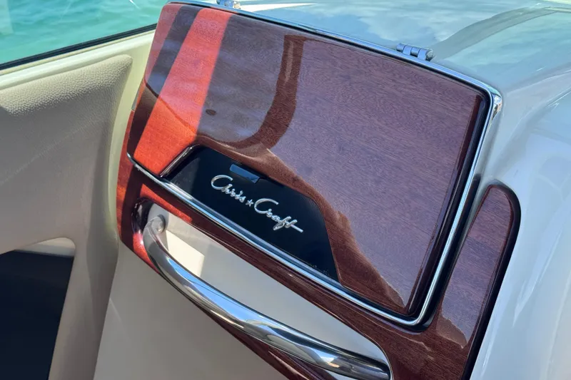 Slide: The Image of 2023 Chris-Craft Launch 25 GT dashboard with elegant wood finish and logo. - 35