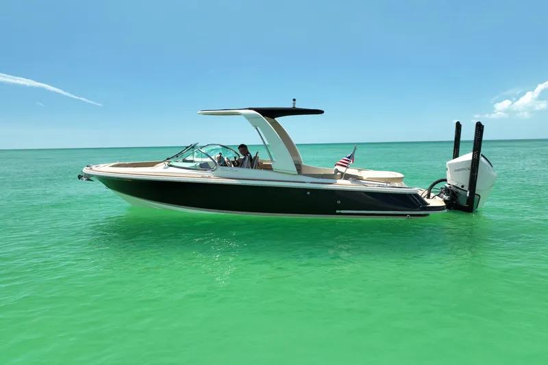 Slide: The Image of 2023 Chris-Craft Launch 25 GT boat on turquoise water, clear sky background. - 4