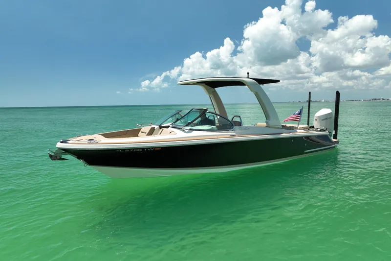 Slide: The Image of 2023 Chris-Craft Launch 25 GT boat on turquoise water under a clear sky. - 5