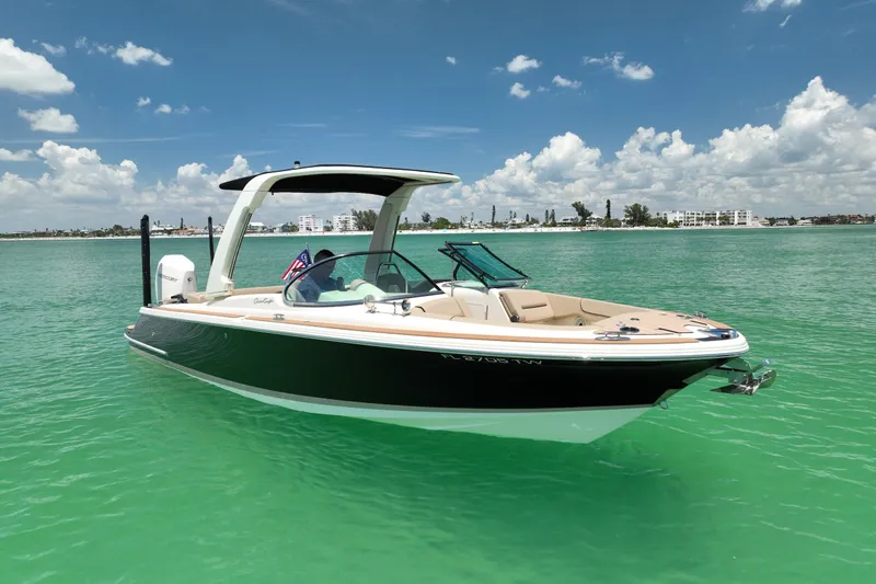 Slide: The Image of 2023 Chris-Craft Launch 25 GT boat on turquoise water under a clear sky. - 6