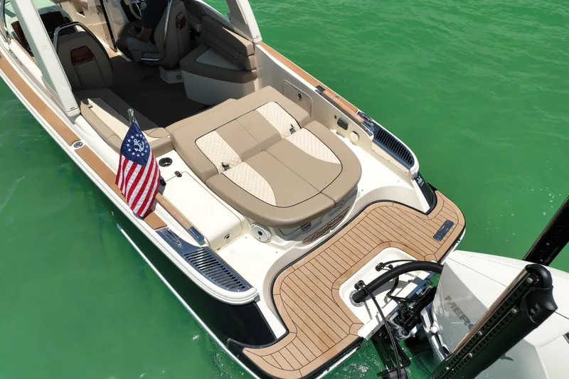 Slide: The Image of 2023 Chris-Craft Launch 25 GT boat with elegant seating and American flag on turquoise water. - 8
