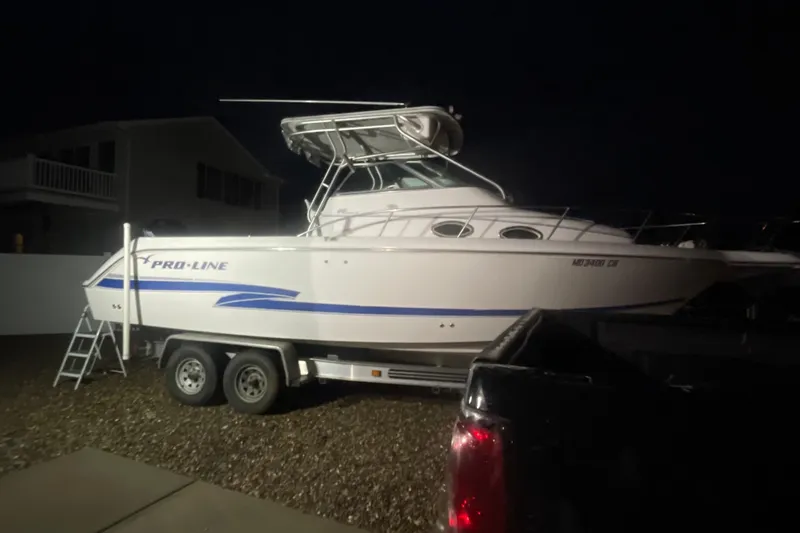 Slide: The Image of 2002 Pro-Line 260 Walkaround boat on trailer at night, side view. - 3
