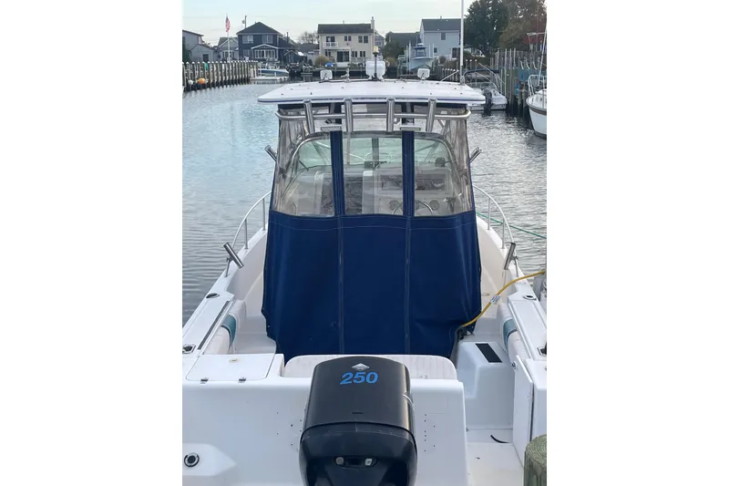 Slide: The Image of 2002 Pro-Line 260 Walkaround boat docked in a serene marina setting. - 5