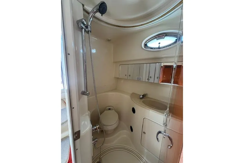 Slide: The Image of 2002 Sea Ray 360 Sundancer bathroom with shower, toilet, sink, and storage cabinets. - 18