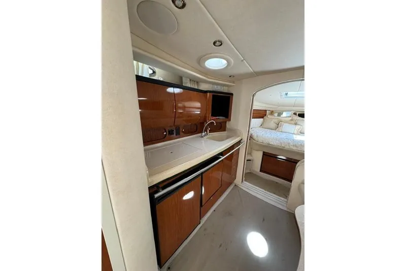 Slide: The Image of 2002 Sea Ray 360 Sundancer interior with kitchenette and cozy sleeping area. - 19